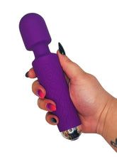 Purple toy held in a hand with a white background