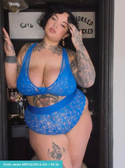 Person wearing a blue lace lingerie set with tattoos visible.